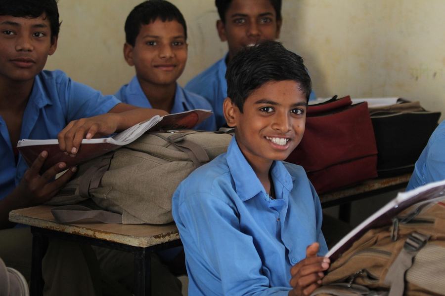 Smiling school students in uniform in a classroom